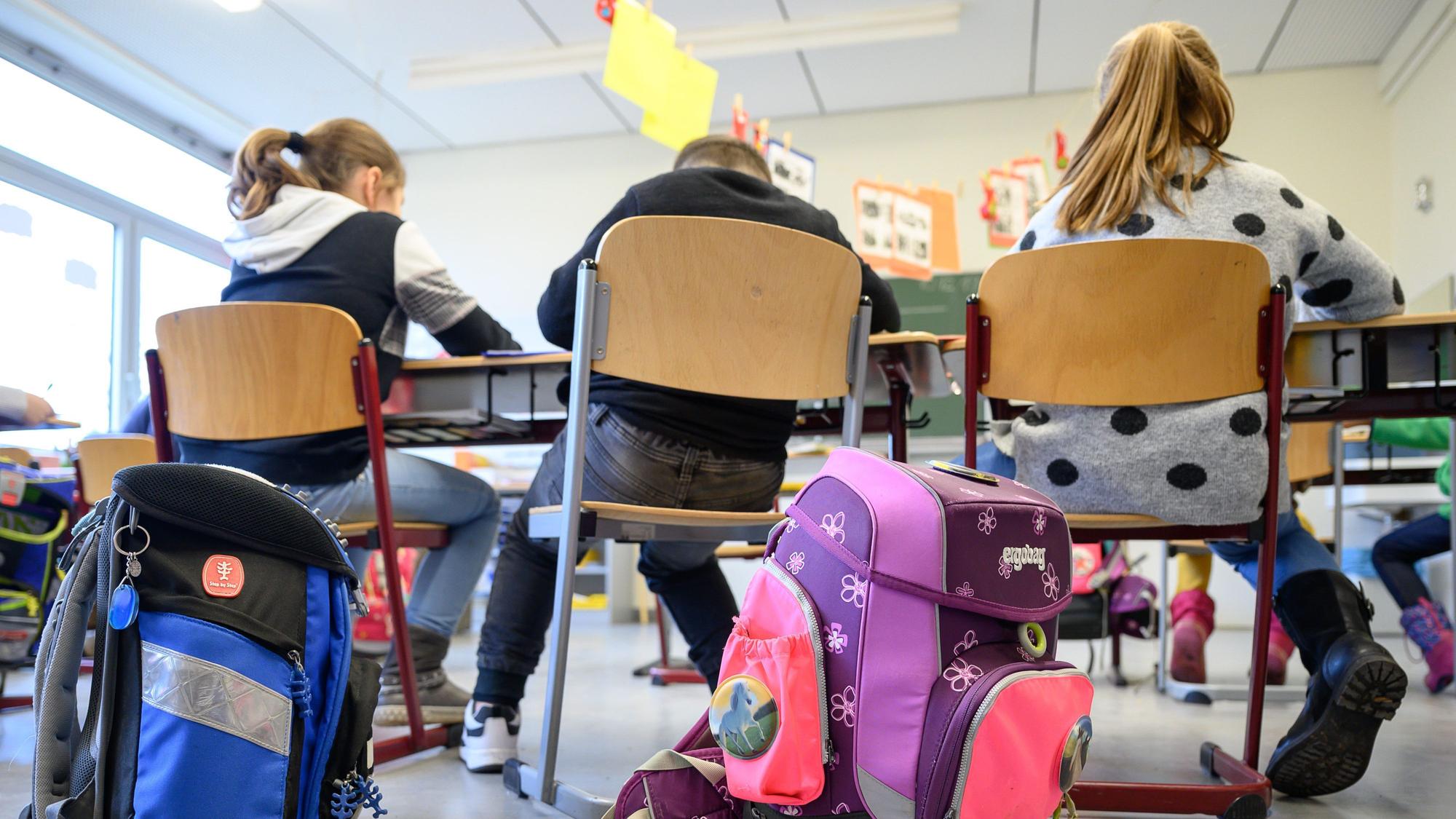 Schulranzen stehen in einer Grundschule.