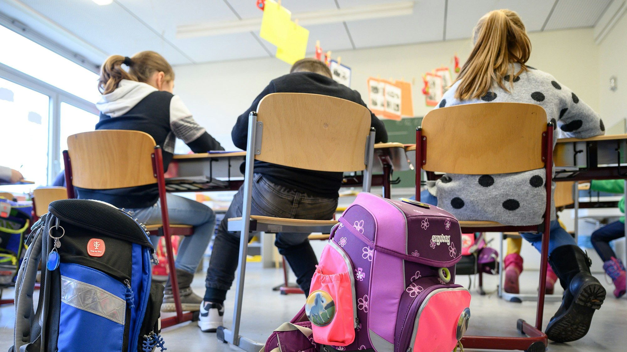 Schulranzen stehen in einer Grundschule.
