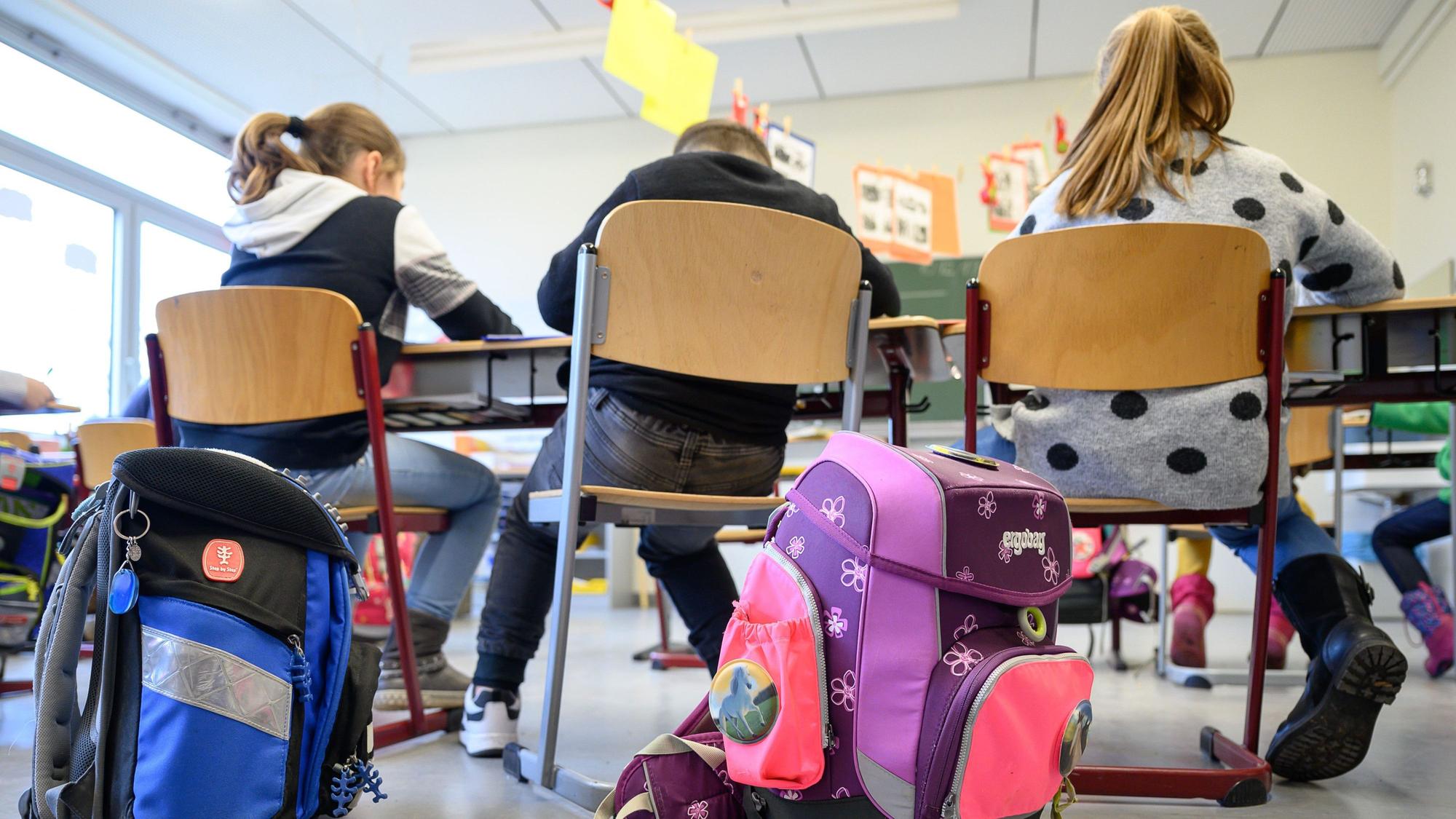 Grundschüler sitzen nebeneinander im Klassenraum.