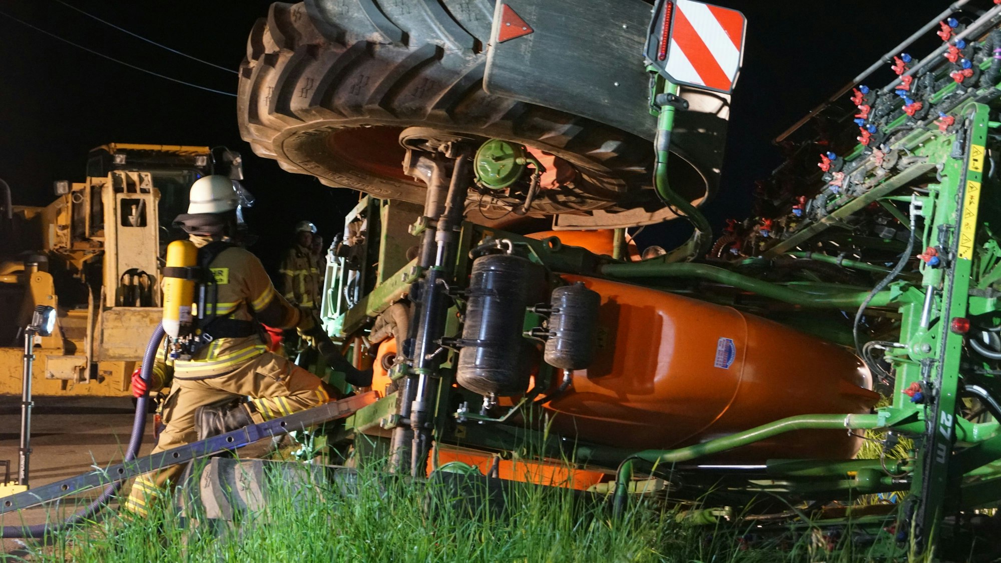 Eine umgekippte Feldspritze wird von der Feuerwehr abgedichtet.