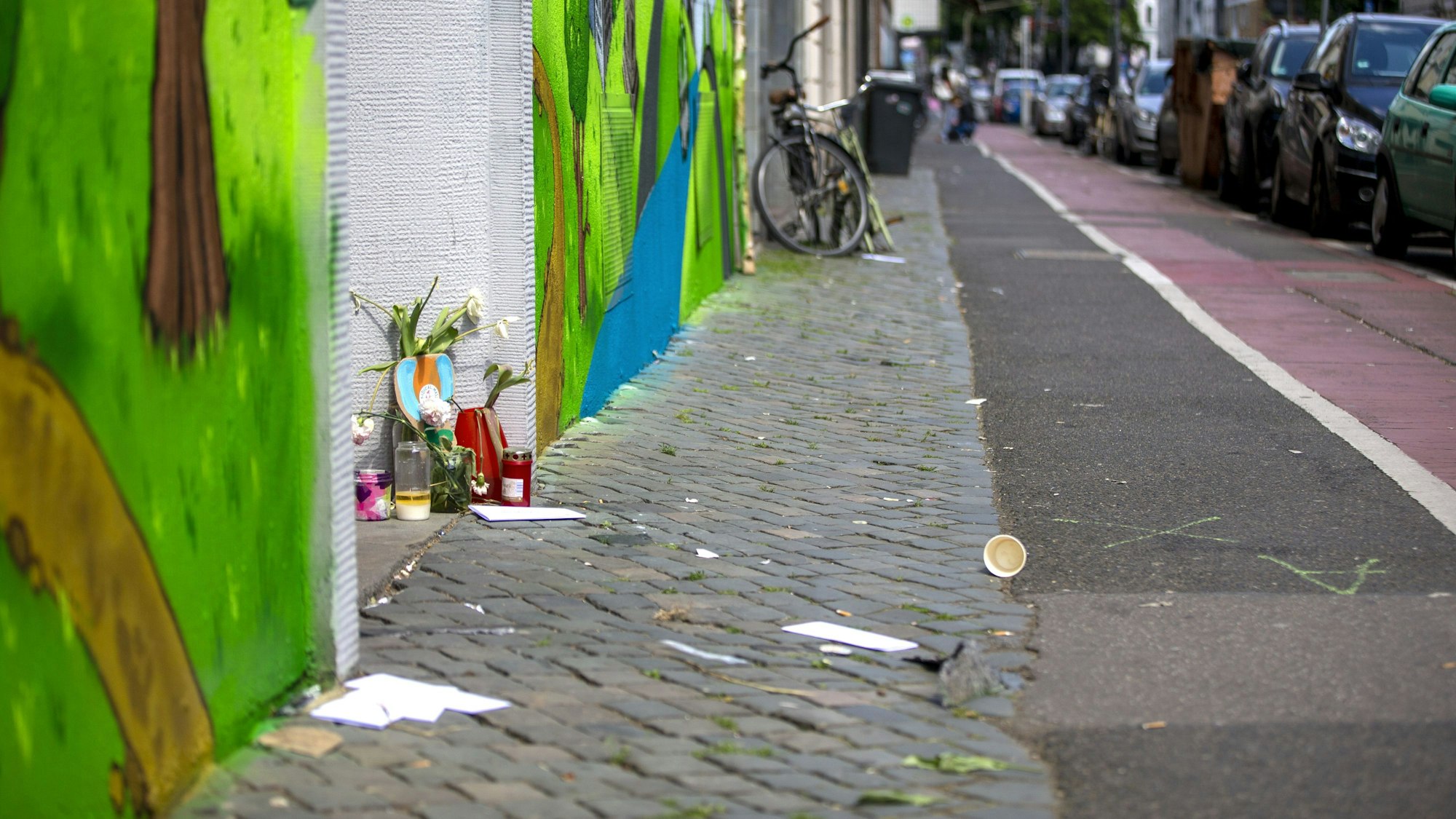 Auf der Lindenstraße sind Blumen und Kerzen in Gedenken an die verstorbene Seniorin niedergelegt worden. Dort starb eine Fußgängerin nach einem Zusammenprall mit einem Radler.