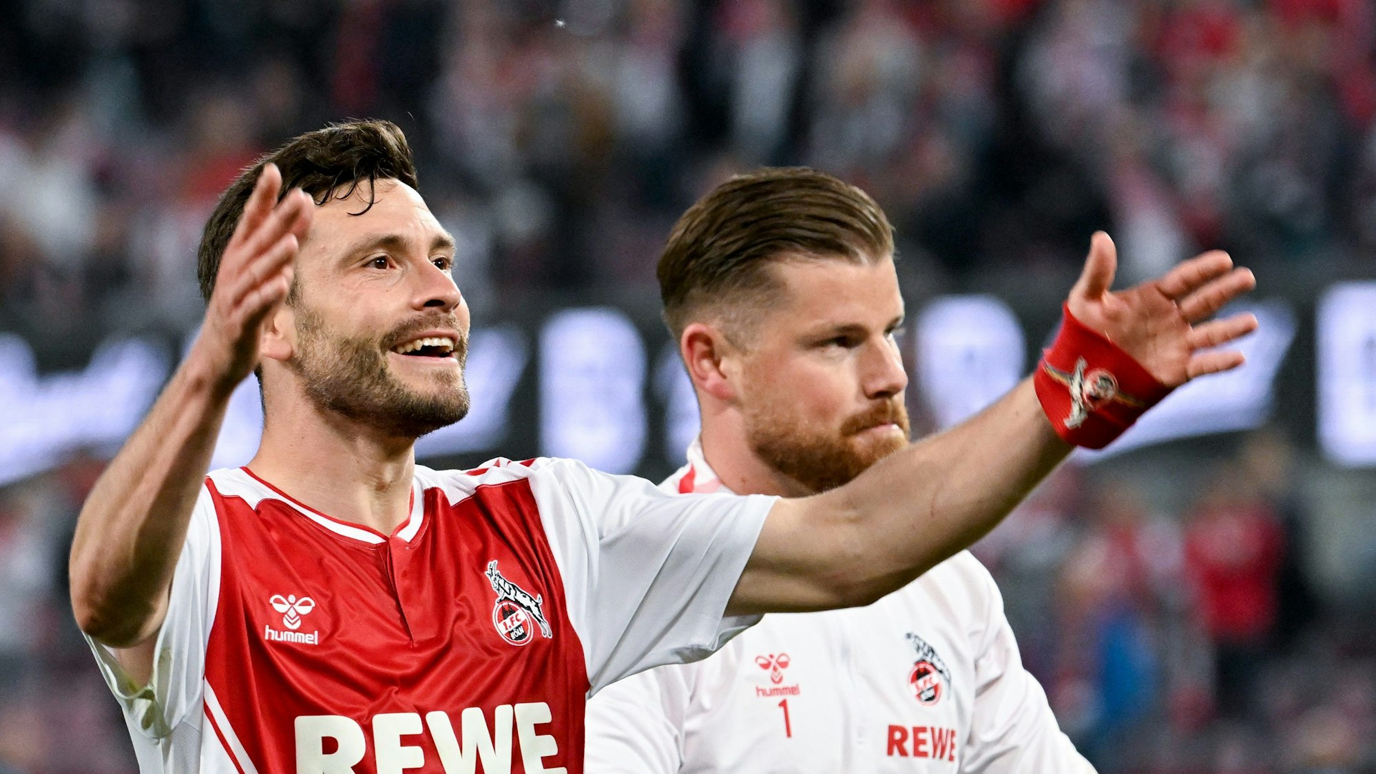 12.05.2023, Nordrhein-Westfalen, Köln: Fußball: Bundesliga, 1. FC Köln - Hertha BSC, 32. Spieltag, RheinEnergieStadion. Kölns Jonas Hector (l) und Torhüter Timo Horn jubeln nach dem Spiel vor den Fans. Foto: Federico Gambarini/dpa +++ dpa-Bildfunk +++