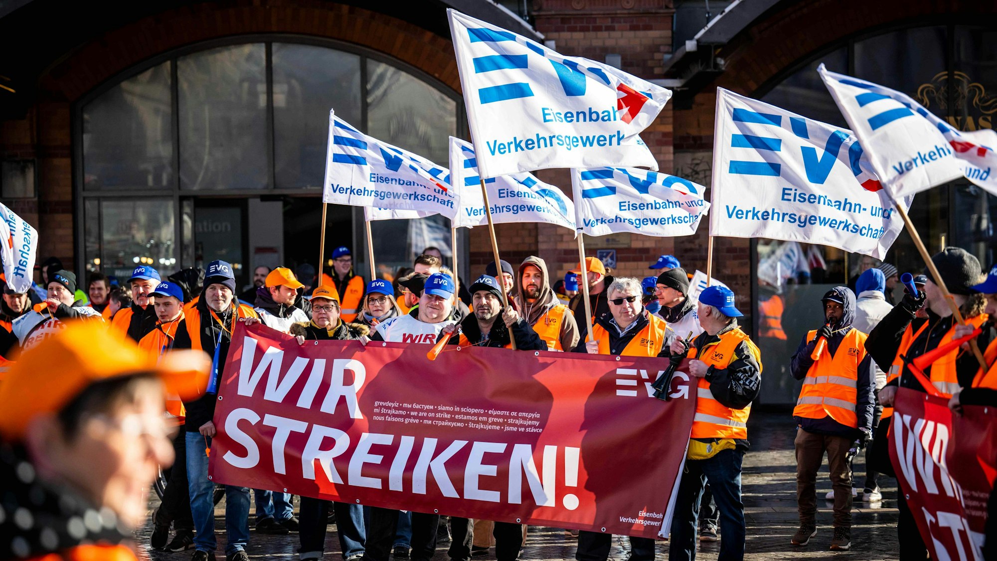 Demonstrierende der Eisenbahn- und Verkehrsgewerkschaft (EVG) protestieren am 27. März mit Plakaten vor dem Bremer Hauptbahnhof. Seit Monaten streiten die Gewerkschaft und die Deutsche Bahn um die Löhne.