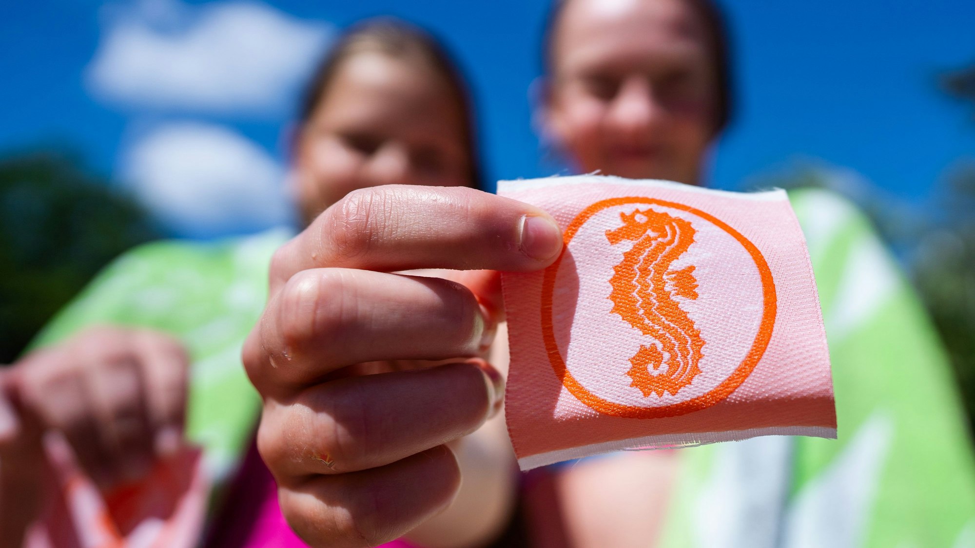 Zwei Mädchen halten ihre Seepferdchen-Abzeichen in den Händen