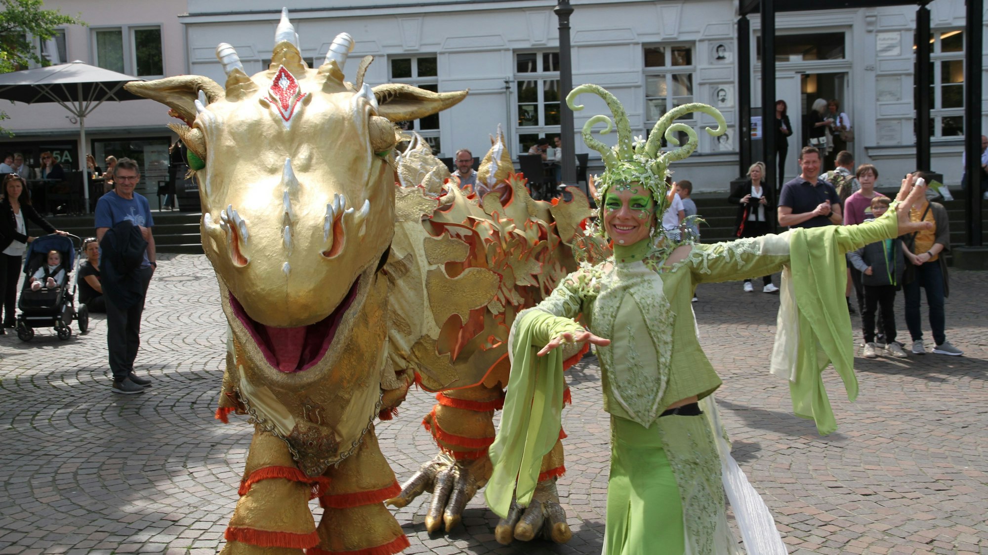 Es ist der goldene Drache mit einer verkleideten Frau daneben zu sehen.