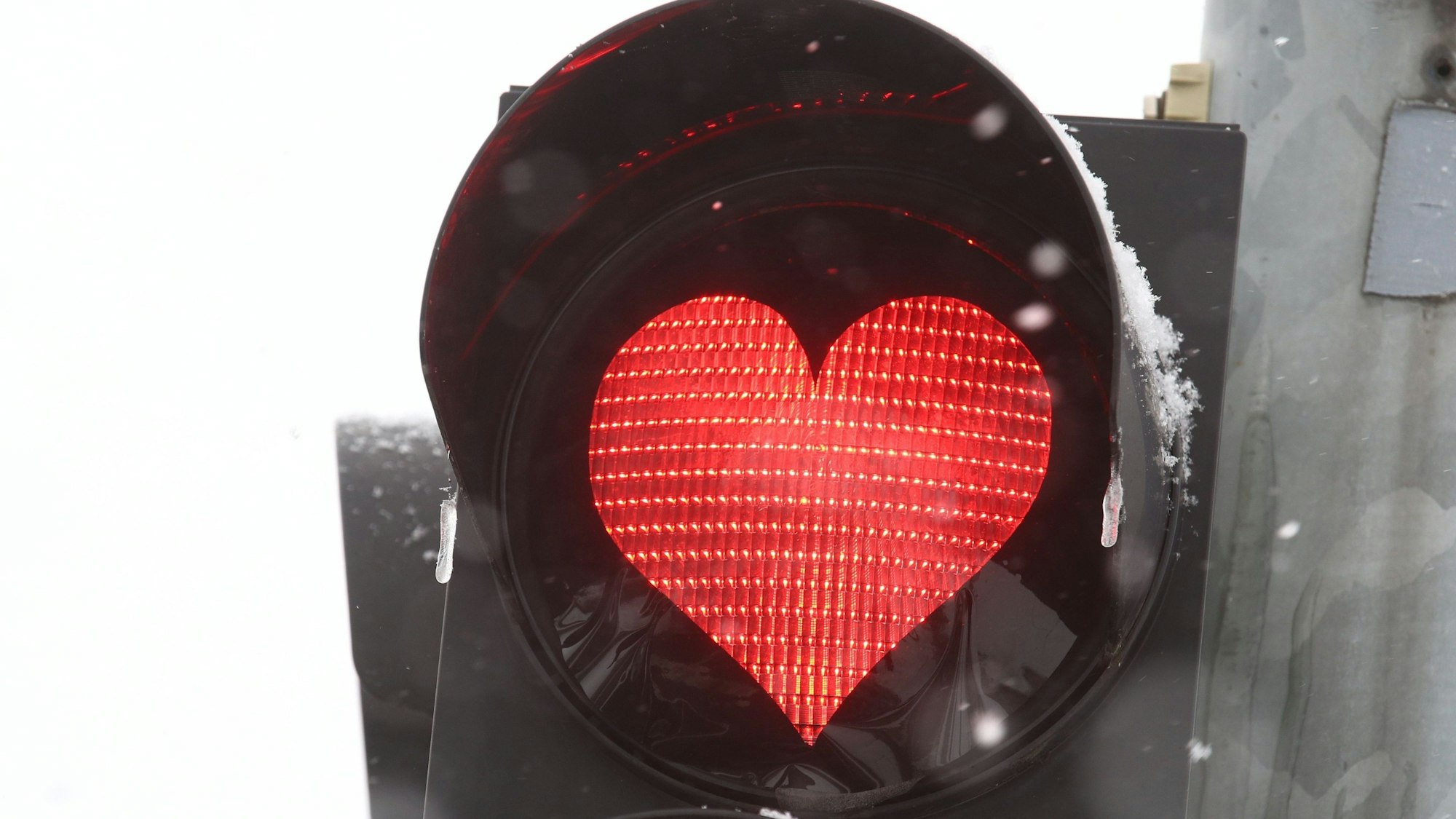 Ein rotes Herz leuchtet an einer Verkehrsampel, eigentlich zu einer Aktion am Valentinstag. Zu einem Fall aus Erfurt passt das Bild aber auch: Ein Paar hatte Sex in einem Auto, weil die rote Ampelphase zu lang war. (Symbolbild)