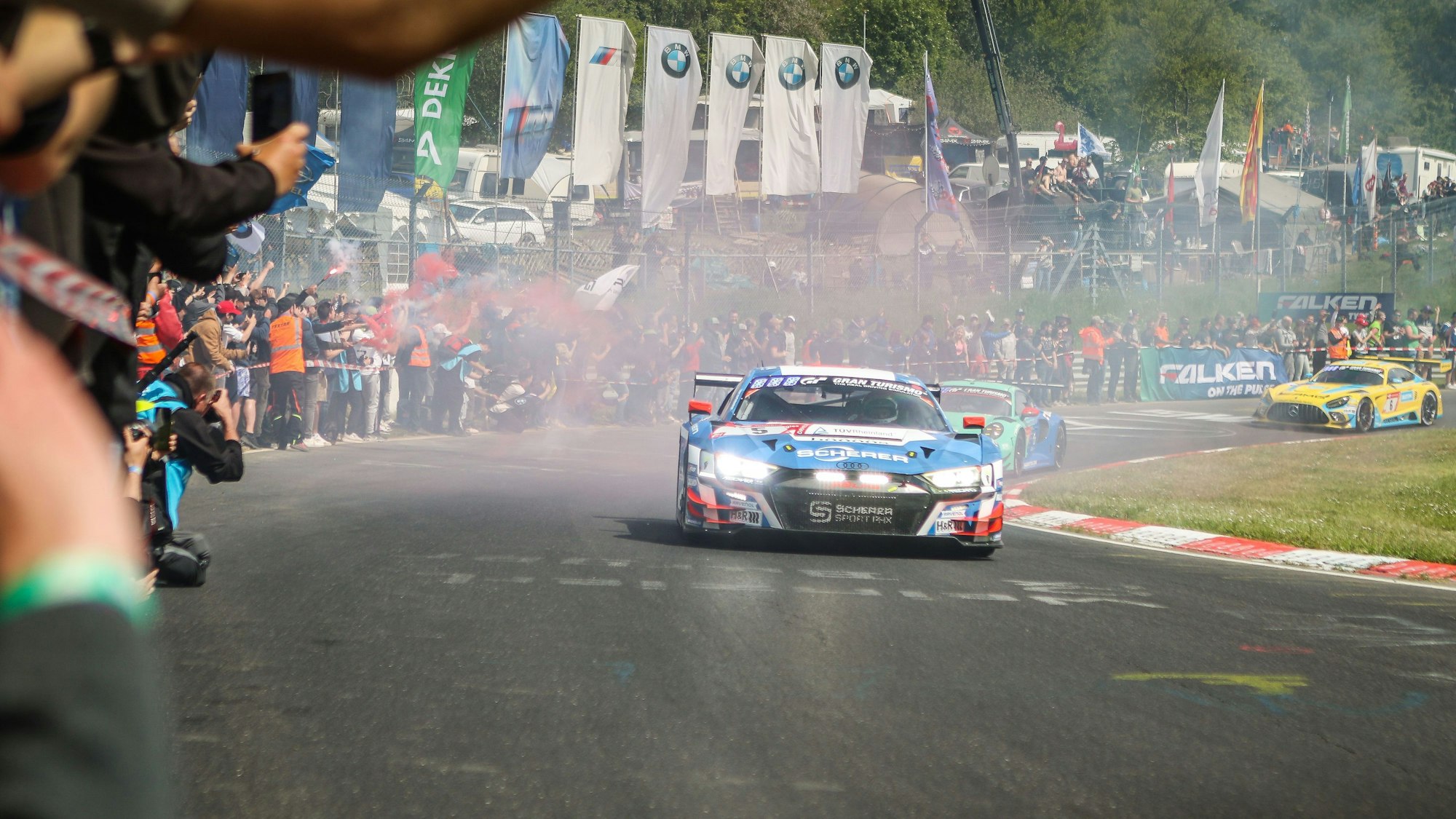 Ein Rennwagen fährt am Publikum vorbei.