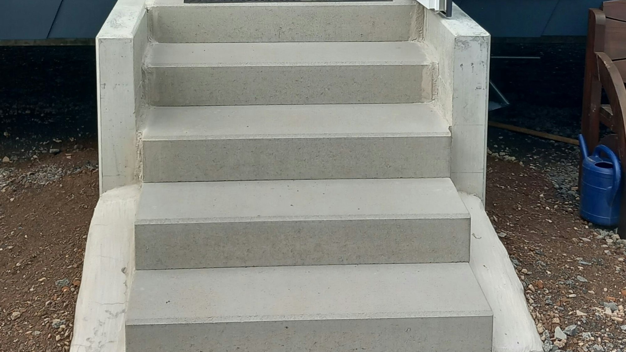 Eine Betontreppe überbrückt am Eingang ins Tiny House den Höhenunterschied.