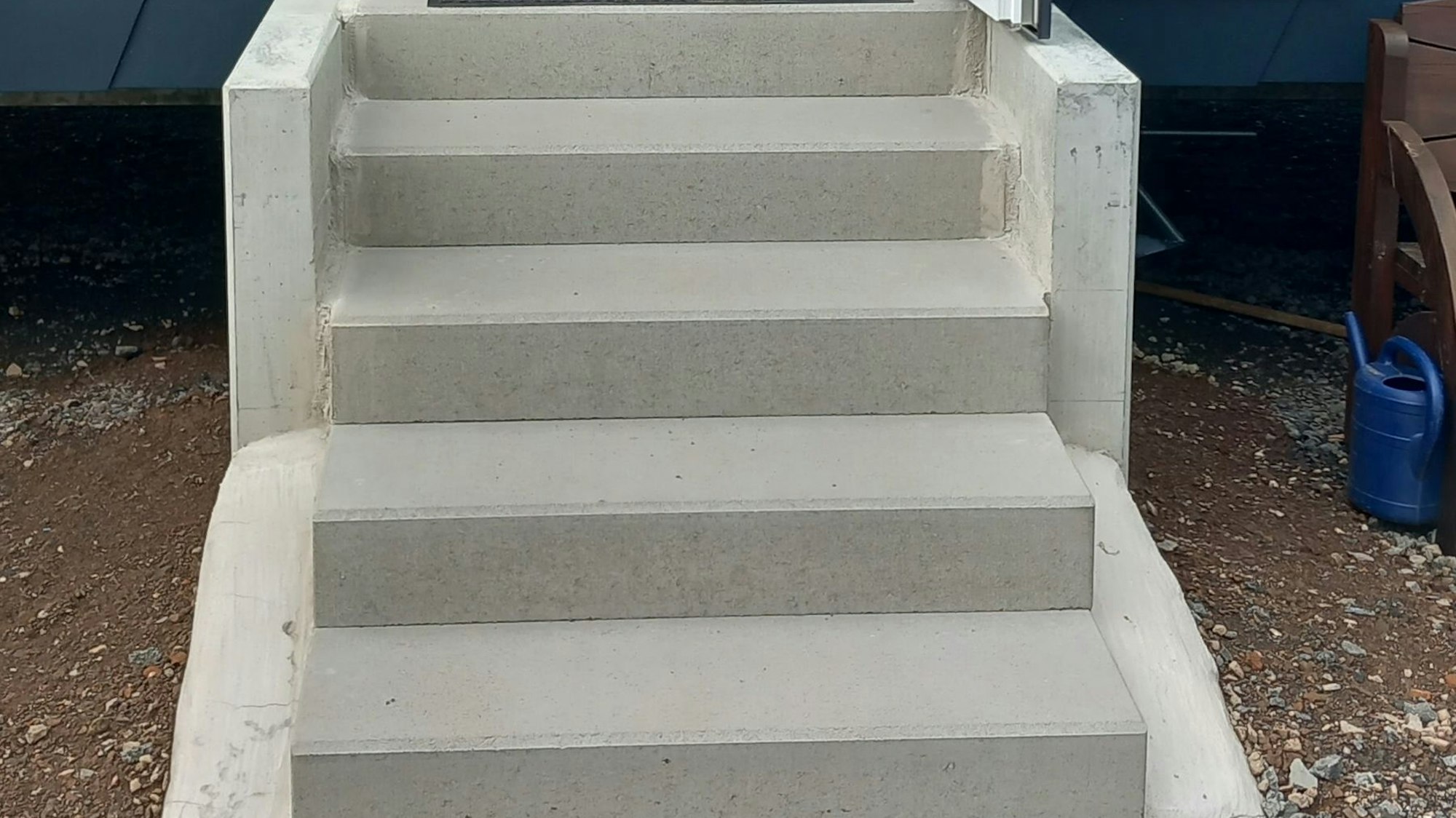 Eine Betontreppe überbrückt am Eingang ins Tiny House den Höhenunterschied.