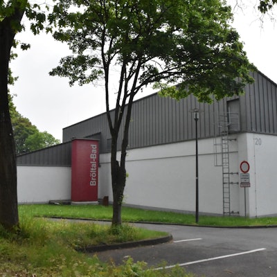 Das Ruppichteroth Bröltalbad ist von außen zu sehen. Davor stehen wenige Bäume.