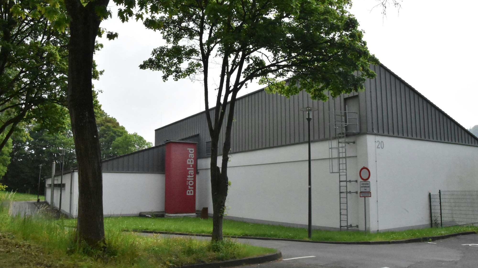 Das Ruppichteroth Bröltalbad ist von außen zu sehen. Davor stehen wenige Bäume.