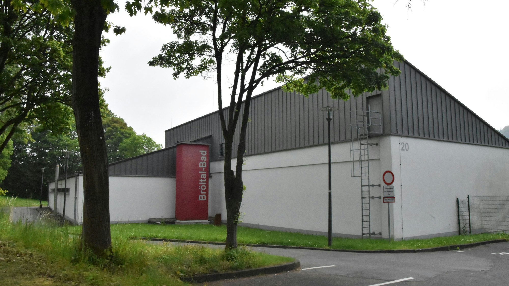 Ein Gebäude mit Schrägdach, an dem das Schild „Bröltal-Bad“ steht.