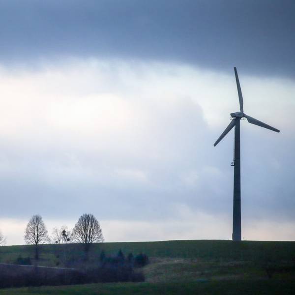 Hinter einem Windrad ziehen Regenwolken auf.