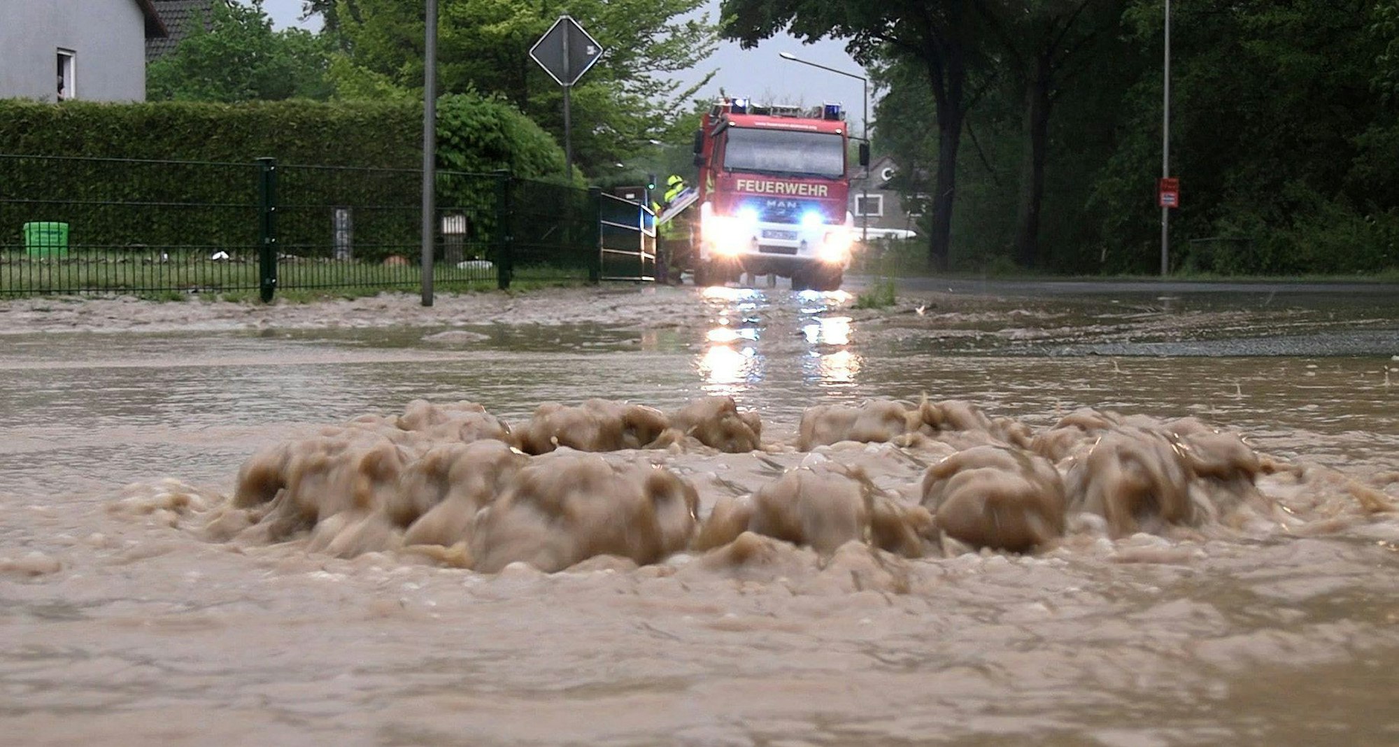 Schwere Unwetter: Wasser tritt aus einem Gullydeckel in Detmold.