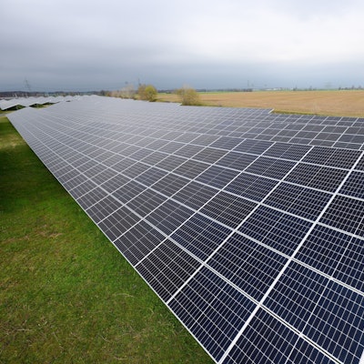 Eine Freiflächen-Solaranlage steht auf einer Wiese.