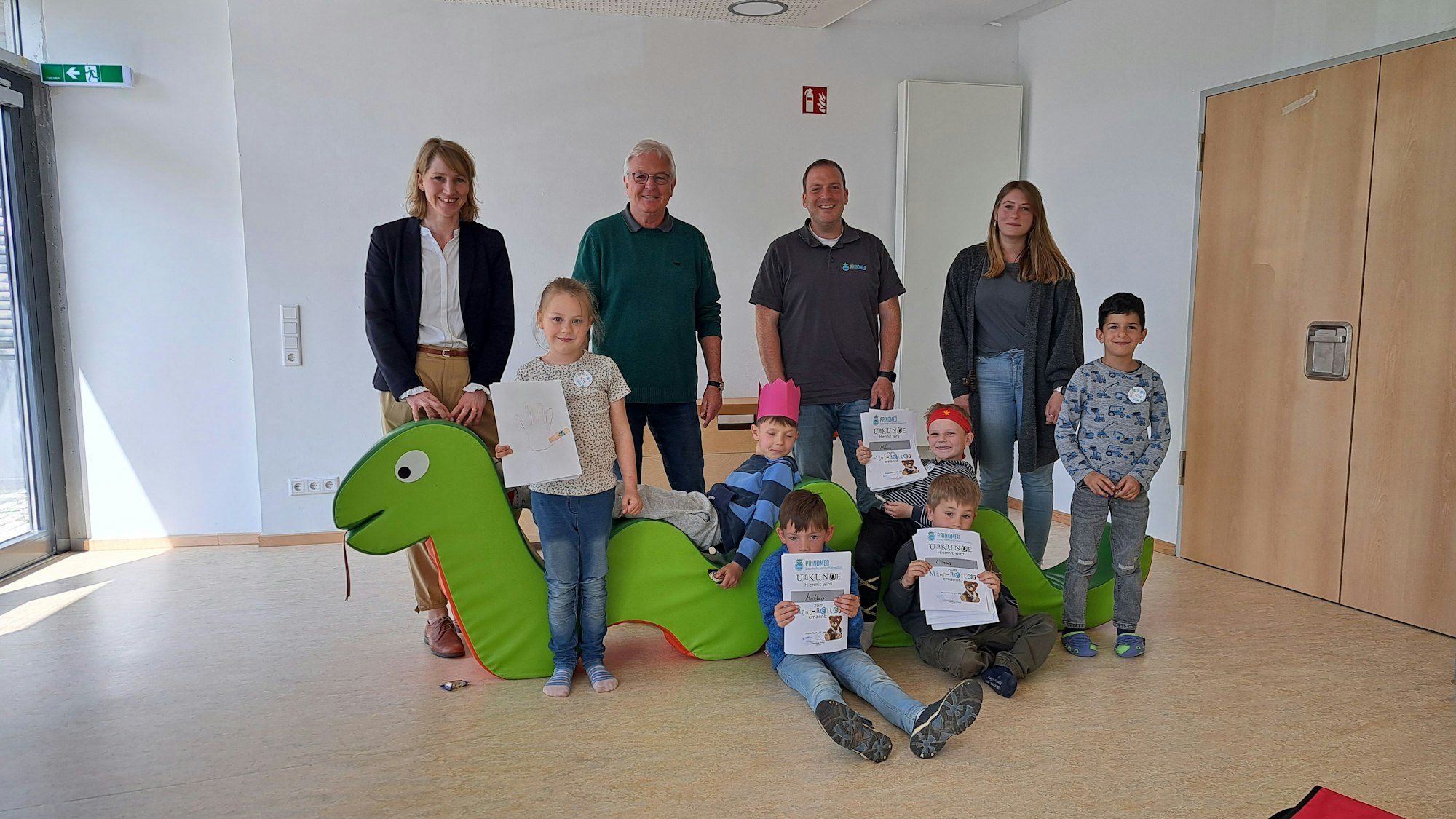 Es sind die Kinder mit ihren Urkunden zu sehen. Vier Erwachsene stehen hinter ihnen.