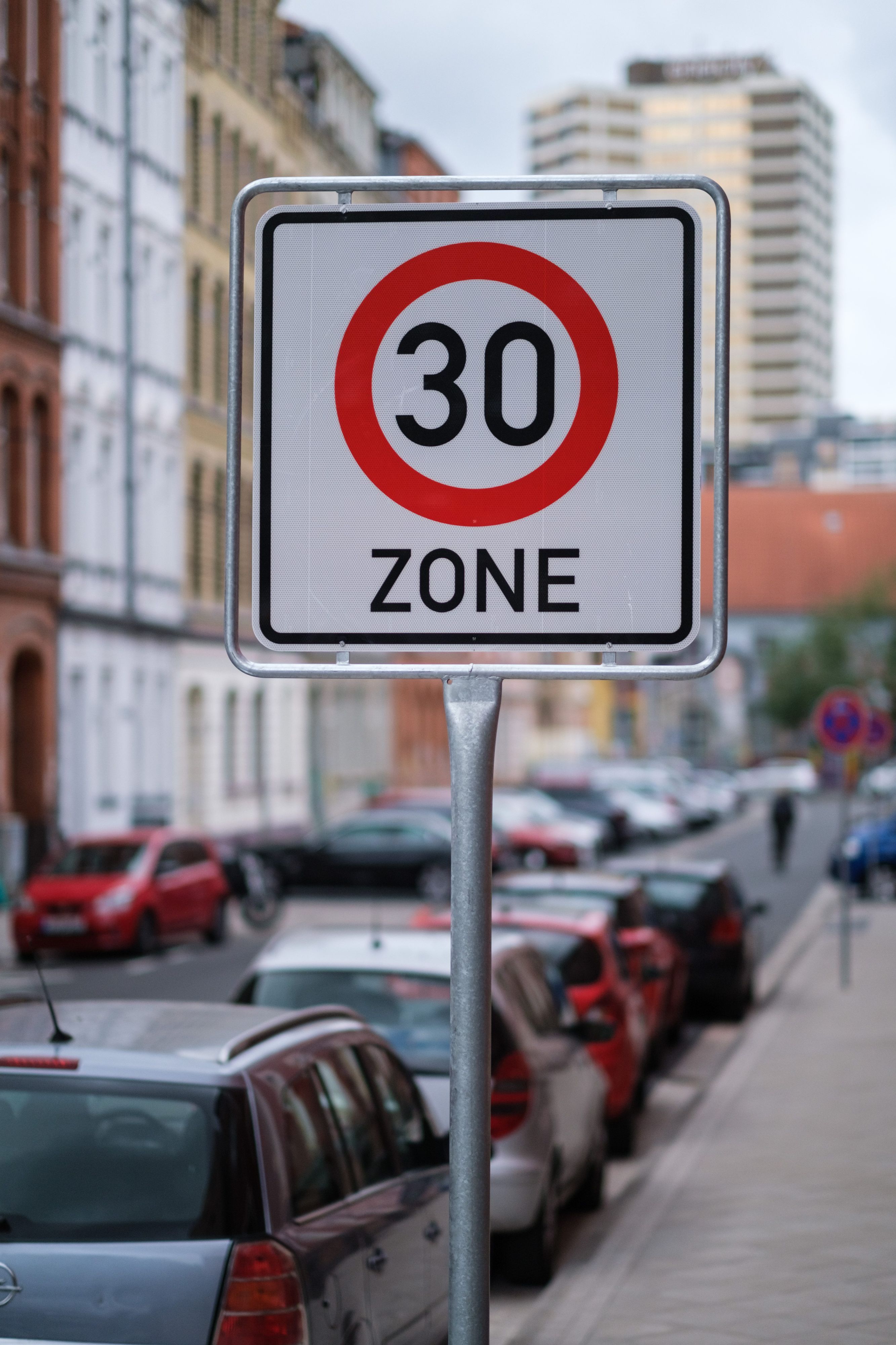 Es sind mehrere parkende Autos an der Straßenseite zu sehen.