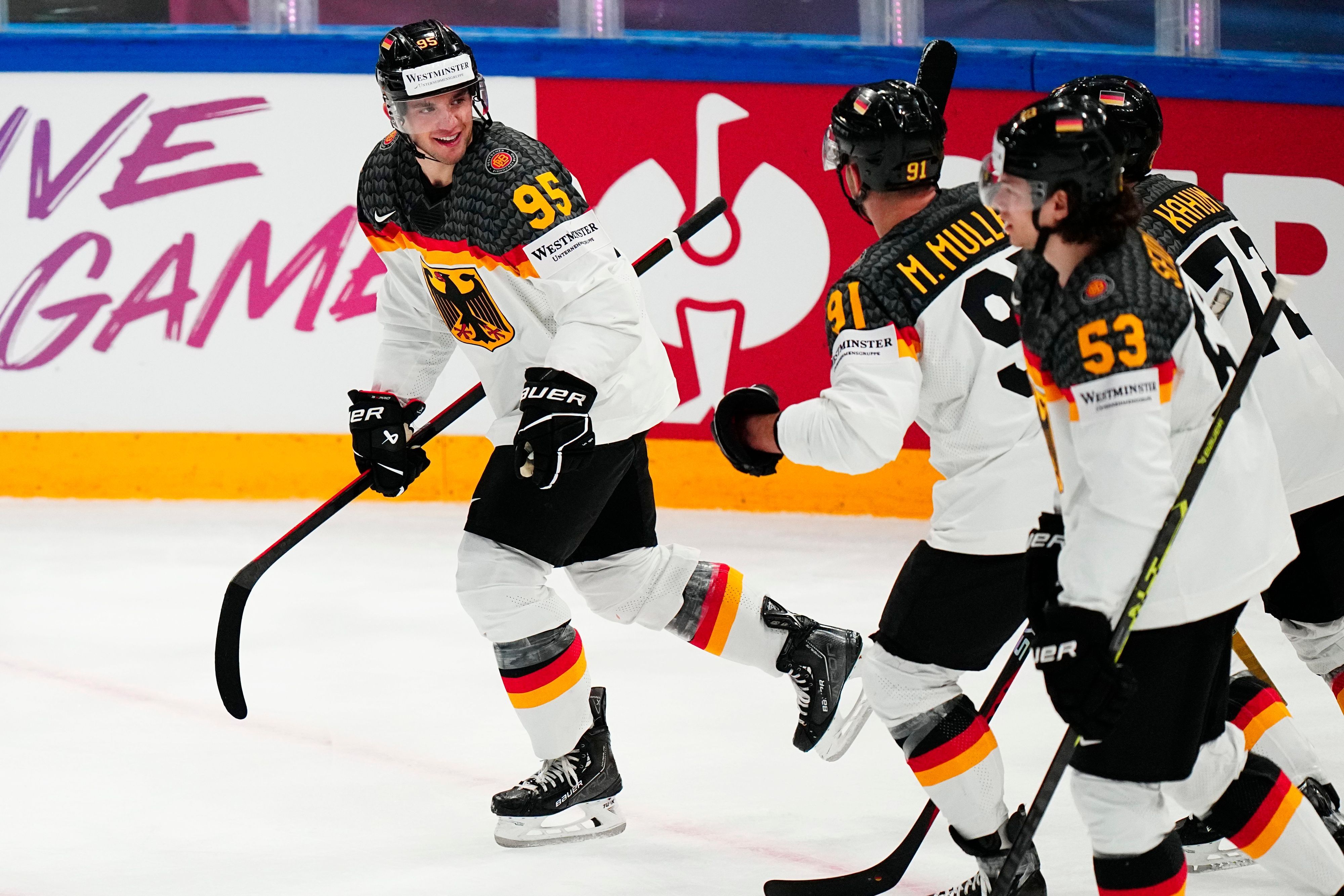 Spieler der deutschen Eishockey-Mannschaft mit Schlägern feiern auf der Spielfläche ein Tor.