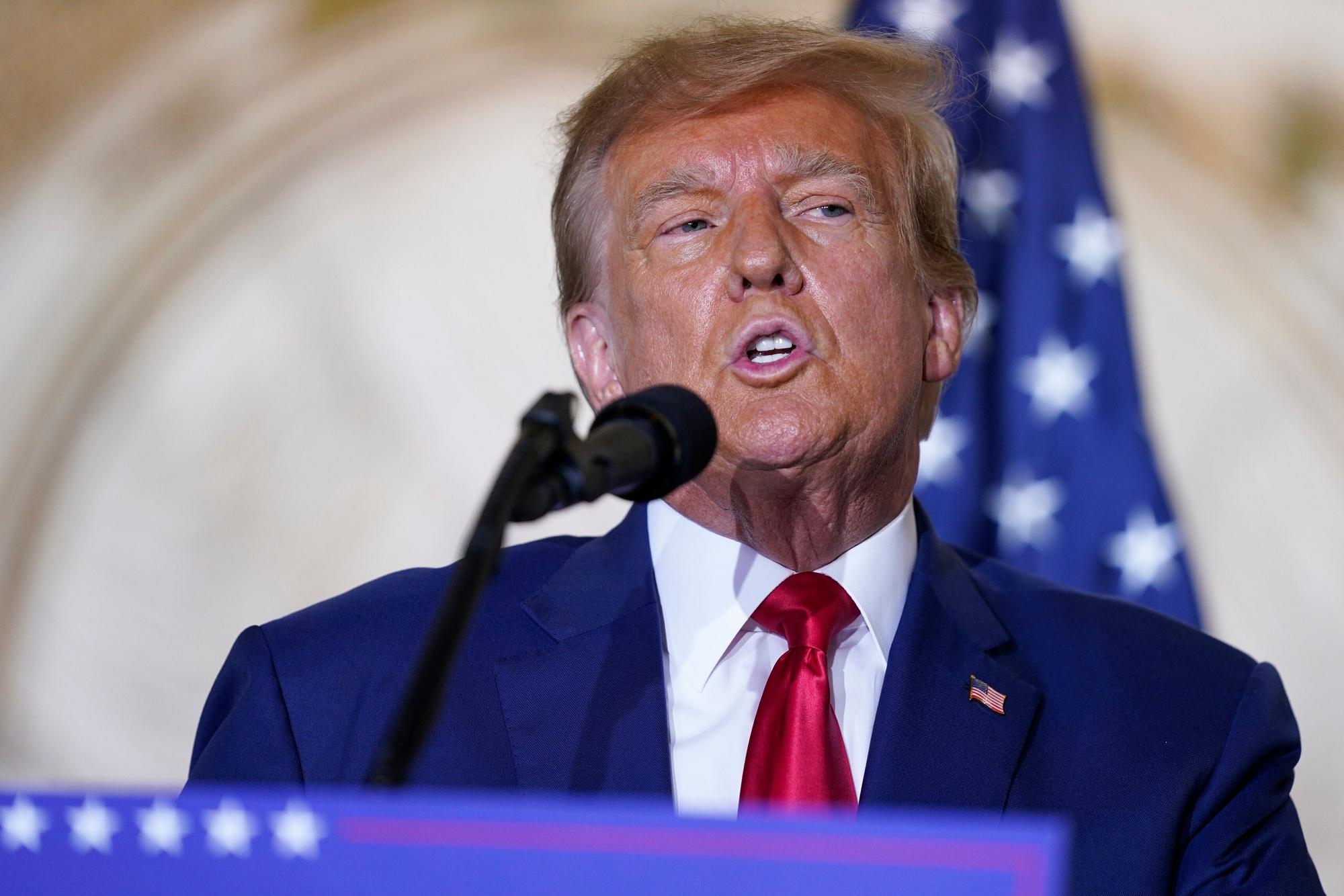 Donald Trump steht vor einem Mikrofon.