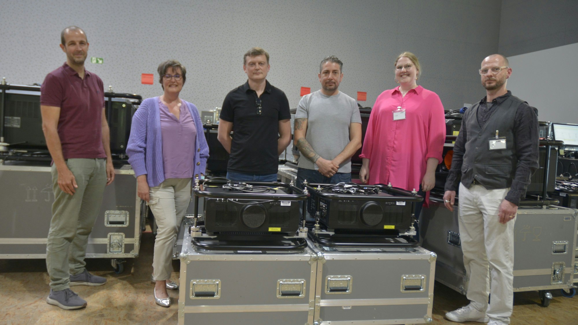 Es sind sechs Menschen zu sehen, die in der Firma stehen.