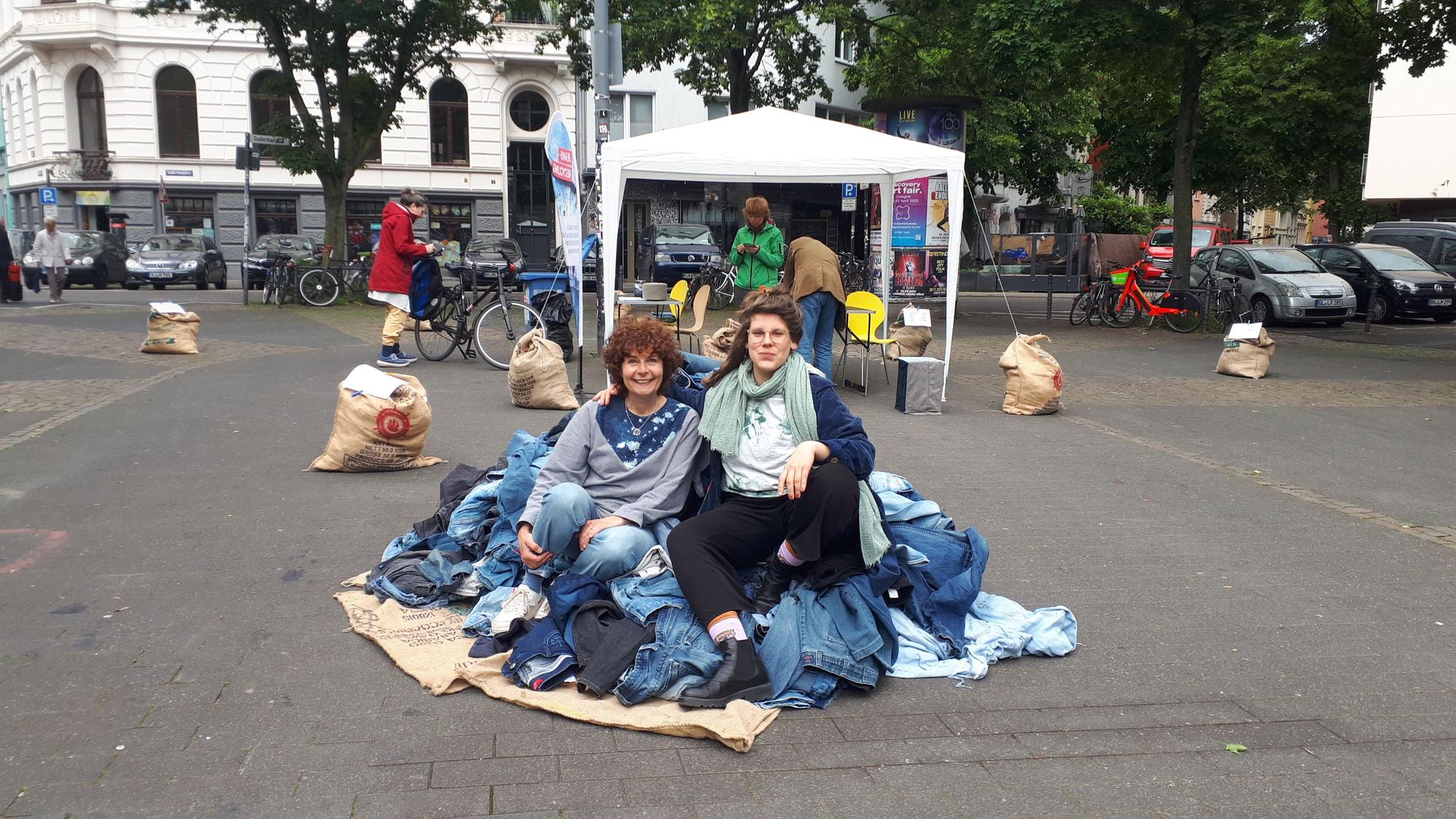Katharina Partyka und Elena Schiff (v.l.) sitzen auf einem Jeansberg.