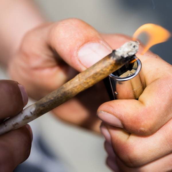 Ein Mann zündet einen Joint an.