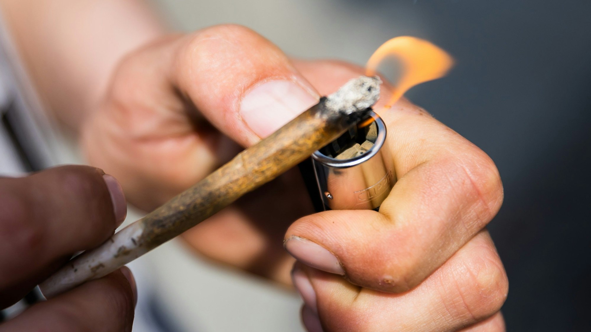 Ein Mann zündet einen Joint an.