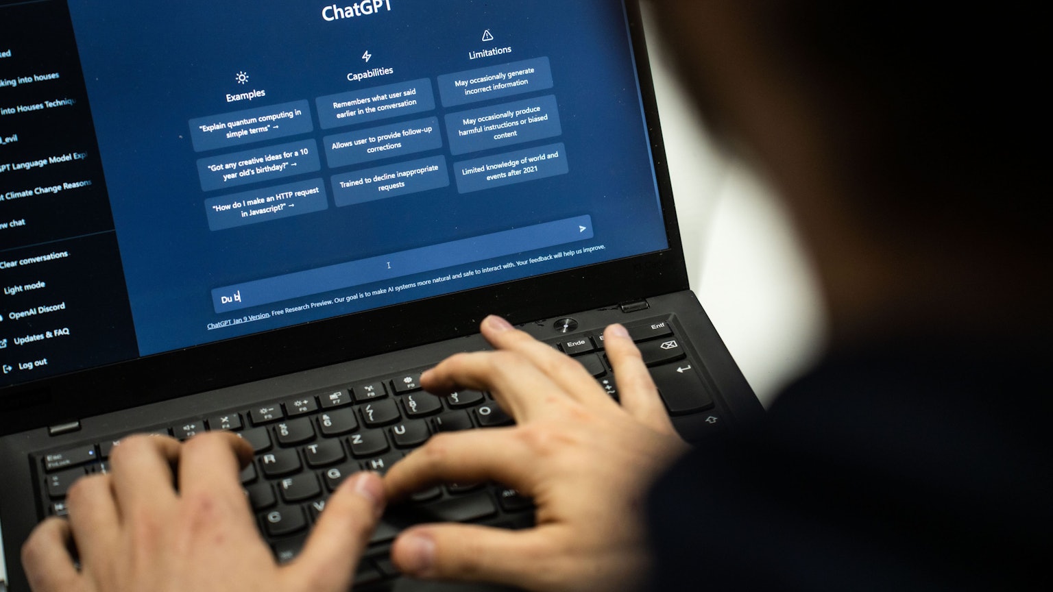 Ein Mensch gibt einen Text in den Text-Roboter ChatGPT ein.