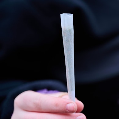 Eine Cannabis-Konsumentin zeigt ihren fertig gedrehten Joint, während sie an einer Demonstration zur Cannabislegalisierung teilnimmt.