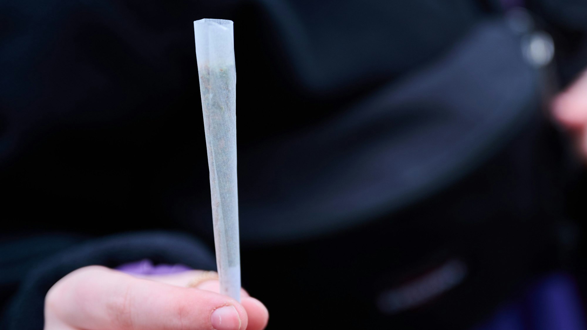 Eine Cannabis-Konsumentin zeigt ihren fertig gedrehten Joint, während sie an einer Demonstration zur Cannabislegalisierung teilnimmt.