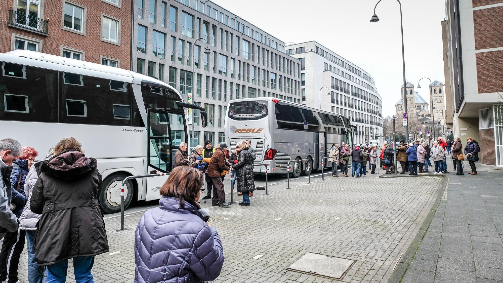 Menschen stehen vor zwei Bussen.