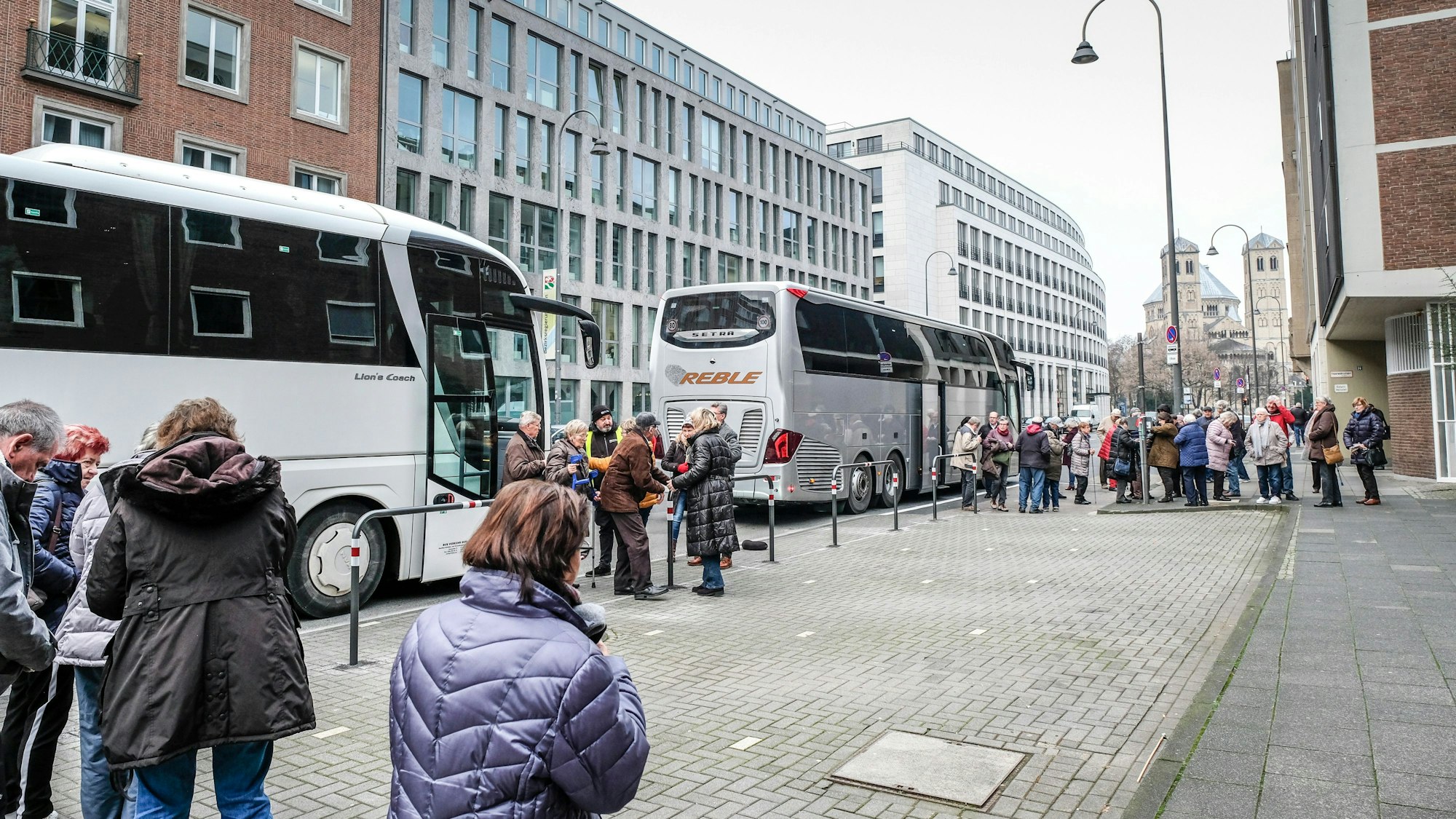 Menschen stehen vor zwei Bussen.