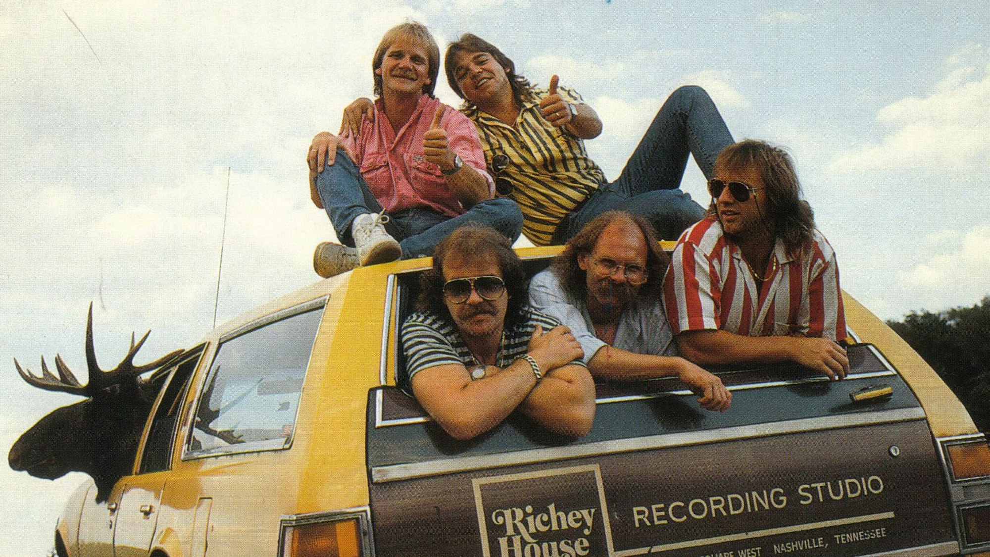 Eine frühe Aufnahme der Paveier, die Gründungsmitglieder waren Klaus Lückerath (oben, v.l.), Micky Brühl sowie Detlef Vorholt (unten v.l.), Bodo Schulz und Bubi Brühl haben sich im und auf dem Auto einer Plattenfirma postiert.