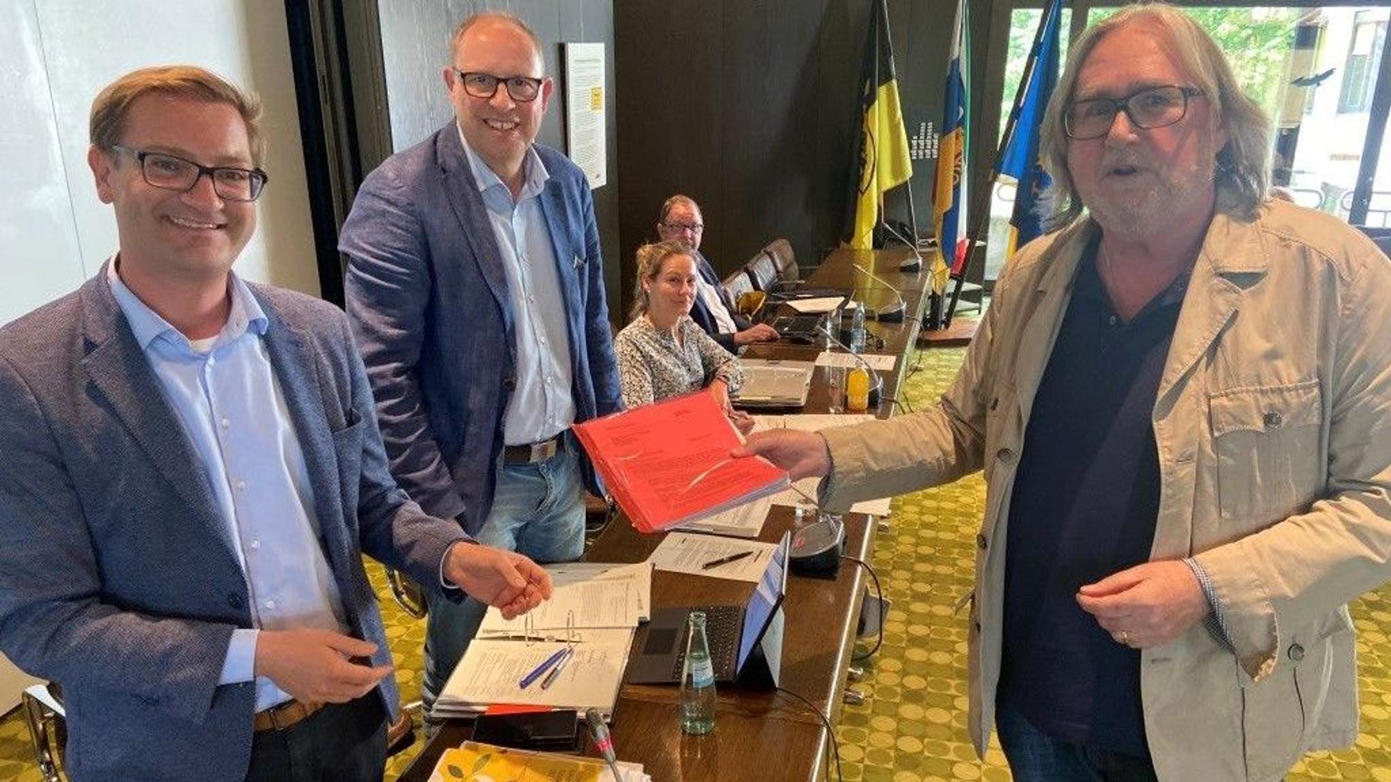 Heribert Voigt (r.) überreichte eine Liste mit mehr als 500 Unterschriften gegen den Verkehrsversuch der Fahrradzone in der Innenstadt an Dezernent Robert Lehmann (l.) und den Vorsitzenden des Ausschusses für Verkehr, Umwelt und Klima, Stefan Hoss (Mitte).