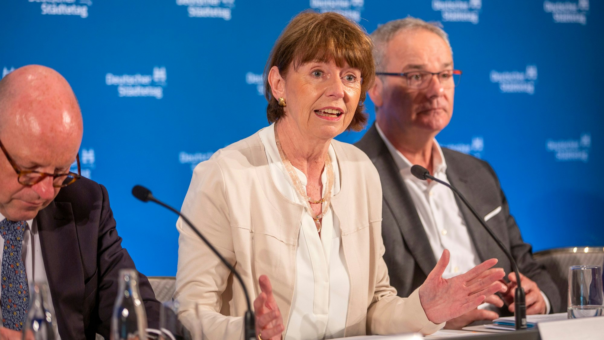 Henriette Reker,
Helmut Dedy und Markus Lewe sitzen bei einer Pressekonferenz an einem Tisch.