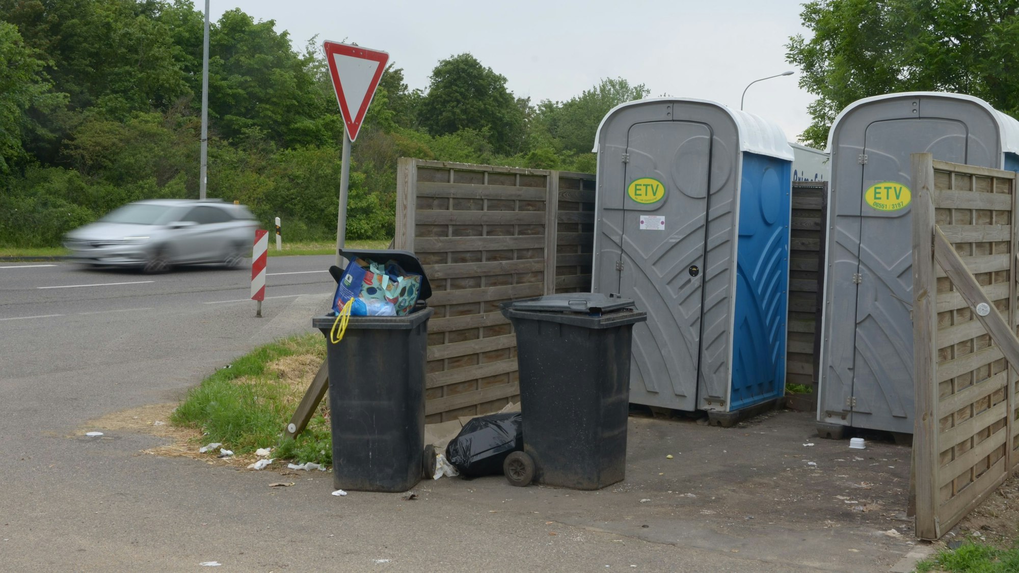 Das Bild zeigt zwei volle Mülltonnen und zwei mobile Toiletten im Euskirchener Industriepark.