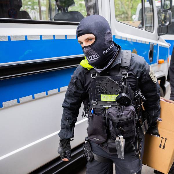 Polizisten tragen bei einer Hausdurchsuchung in Berlin-Kreuzberg einen Karton zu einem Fahrzeug. Polizei und Staatsanwaltschaft haben im Zuge eines Ermittlungsverfahrens zu Mitgliedern der „Letzten Generation“ 15 Objekte in sieben Bundesländern durchsucht.