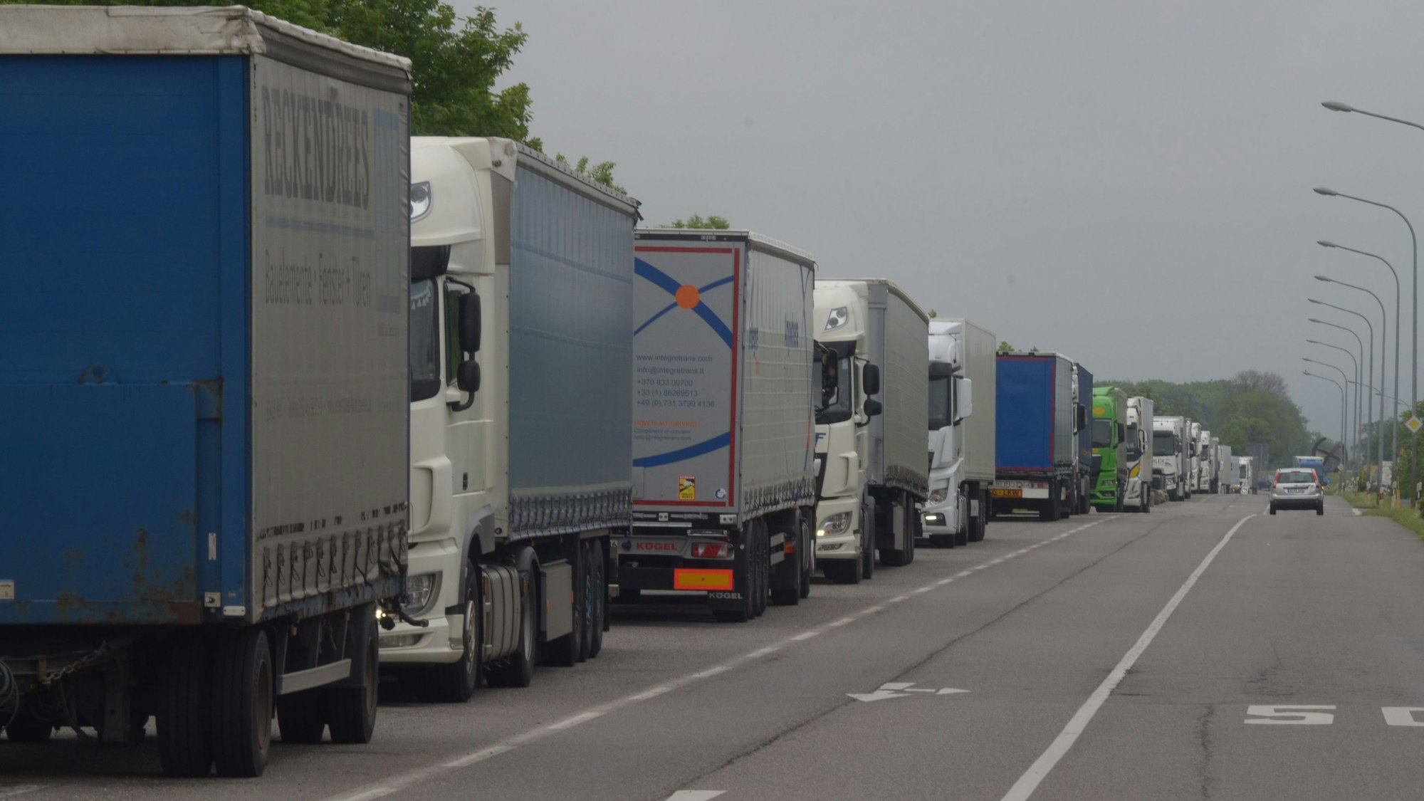 Auf dem Bild sind zahlreiche Lastwagen zu sehen, die in einer langen Schlange an einer Straße in Euskirchen geparkt sind.