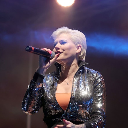 Schlagersängerin Melanie Müller singt auf der Bühne bei einer Autodisco.