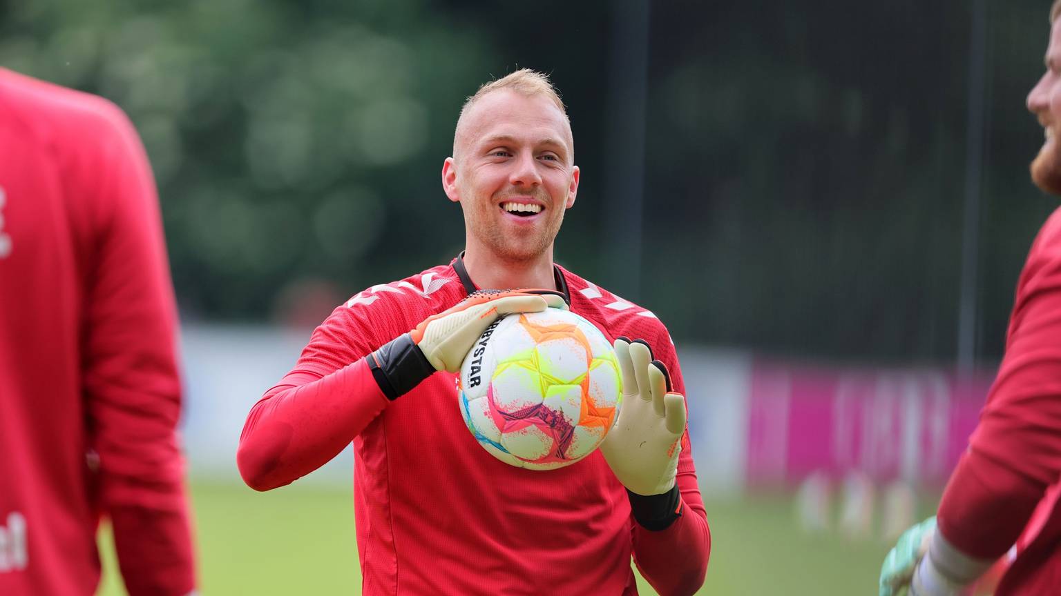 Marvin Schwäbe hält einen Ball in den Händen und lacht