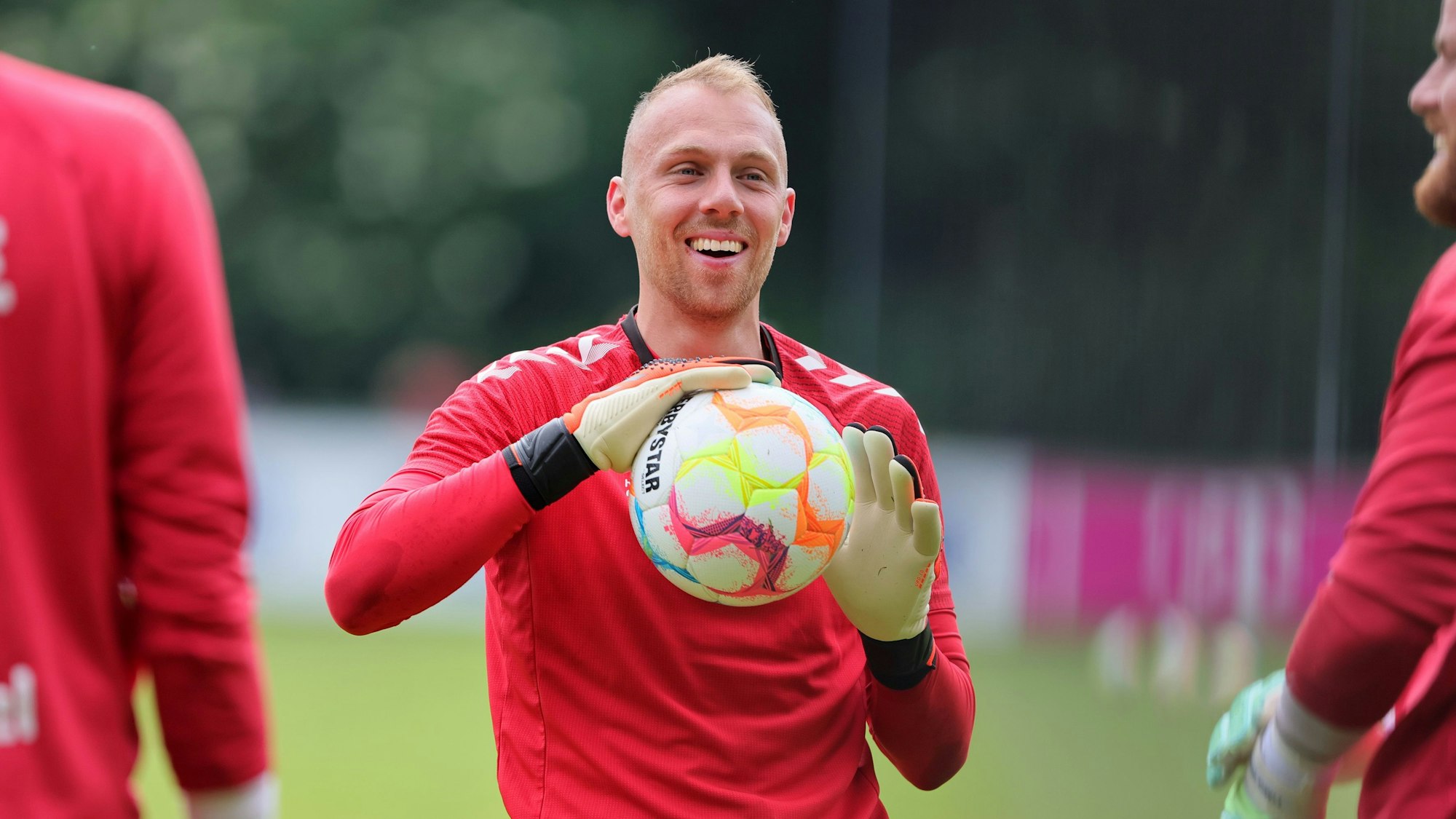 Marvin Schwäbe hält einen Ball in den Händen und lacht