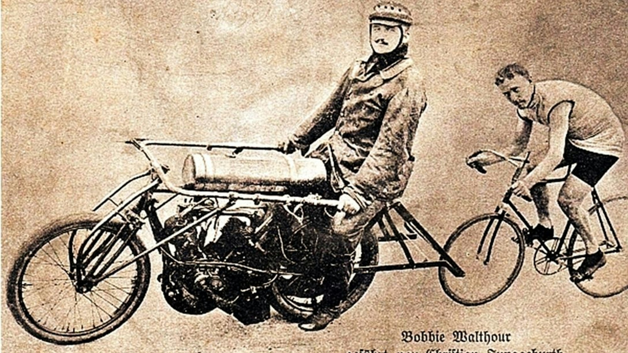 Schrittmacher Christian Junggeburth auf dem Motorrad mit Weltklassefahrer Robert Walthour auf dem Fahrrad auf einer Autogrammkarte von etwa 1910.