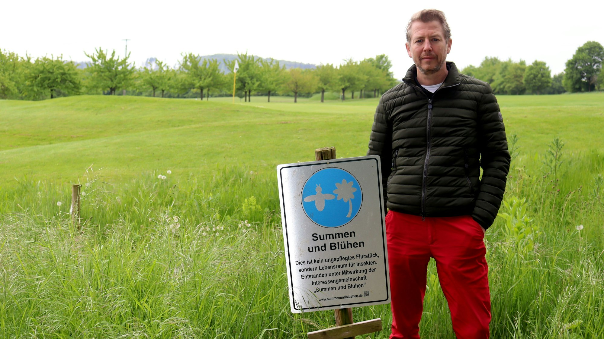 Golfclub-Geschäftsführer Tilman Wrede steht neben einem der HInweisschilder.