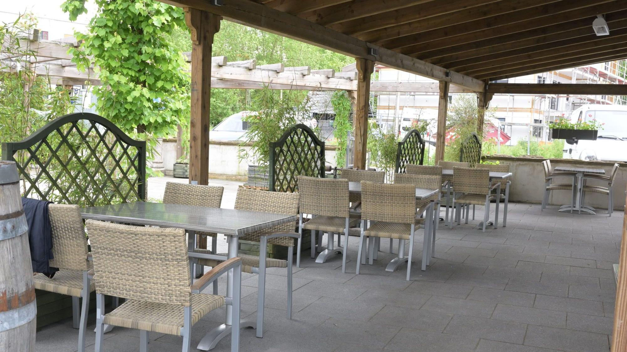 Im Außenbereich des Restaurants stehen Tische und Stühle.