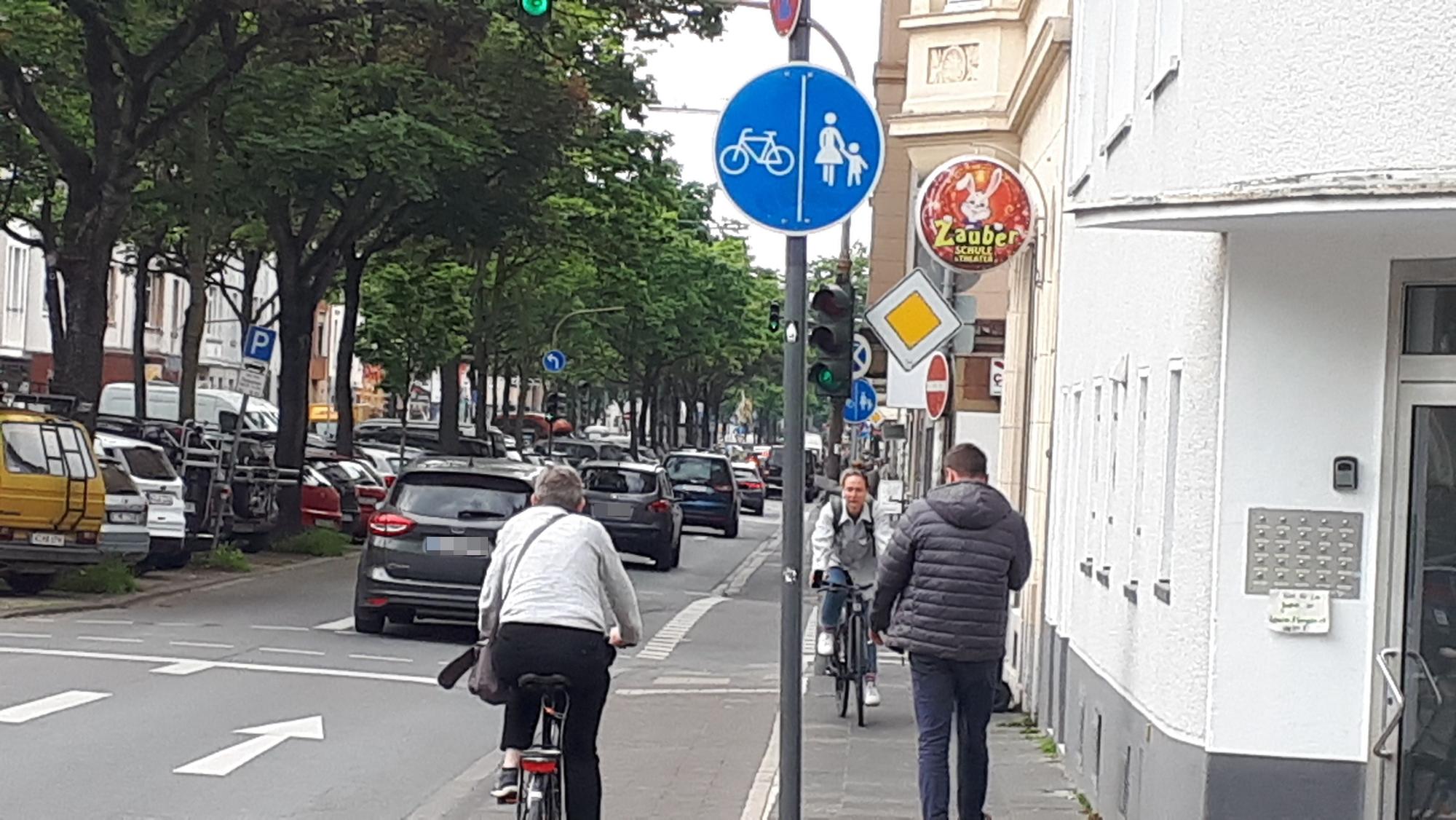 Fahrradfahrer und Fußgänger, die sich auf einem engen Rad- und Fußweg entgegen kommen,
