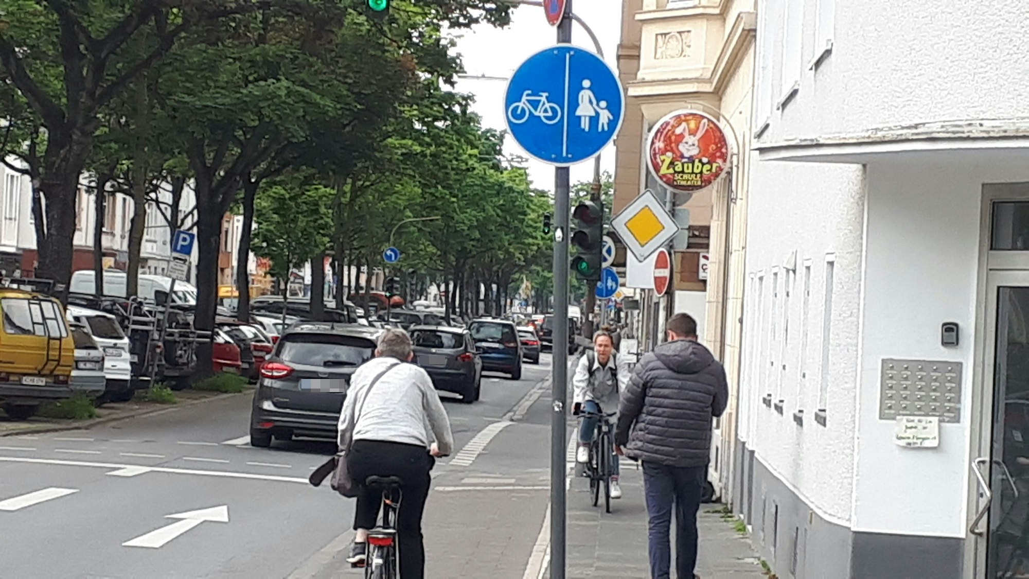 Fahrradfahrer und Fußgänger, die sich auf einem engen Rad- und Fußweg entgegen kommen,