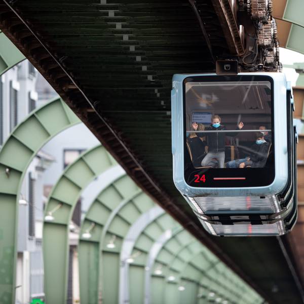 Eine Schwebebahn fährt über der Kaiserstraße in Vohwinkel entlang.