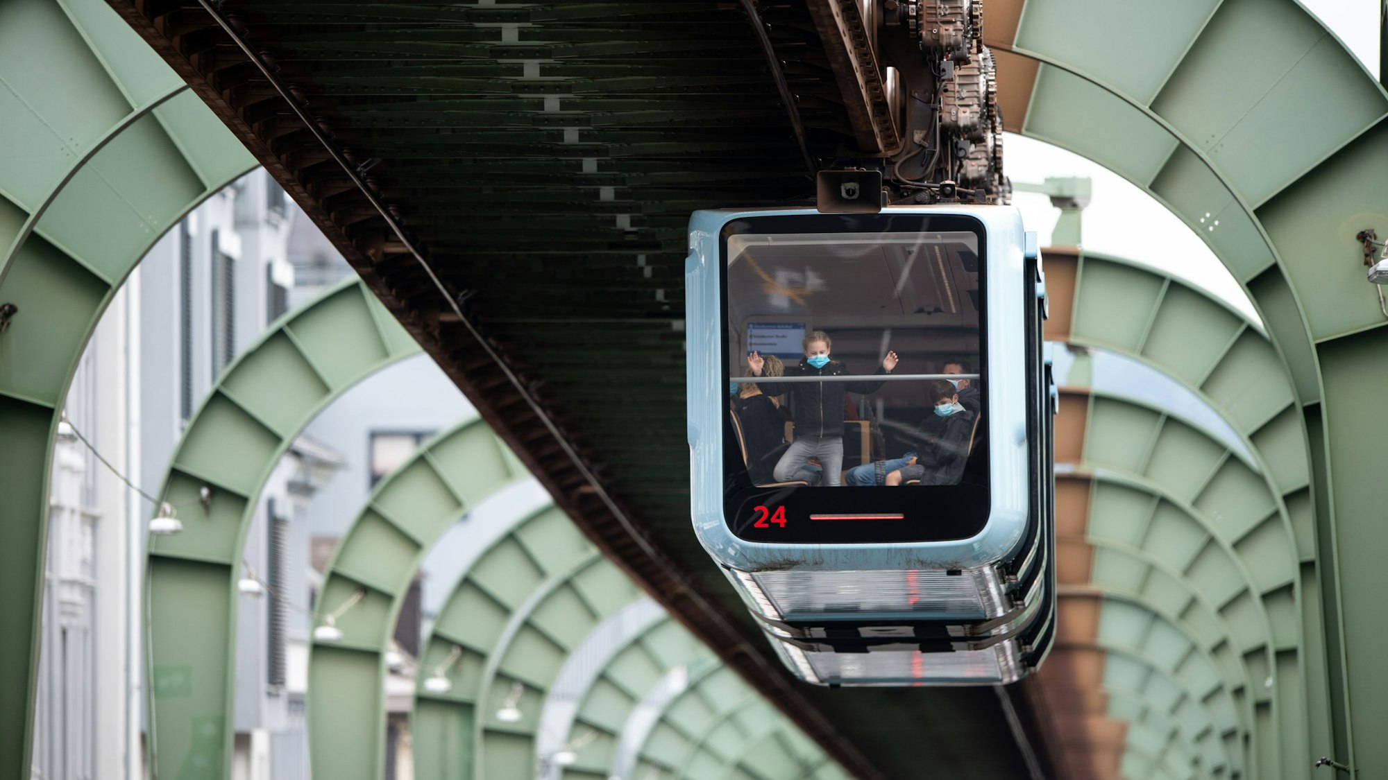 Eine Schwebebahn fährt über der Kaiserstraße in Vohwinkel entlang.