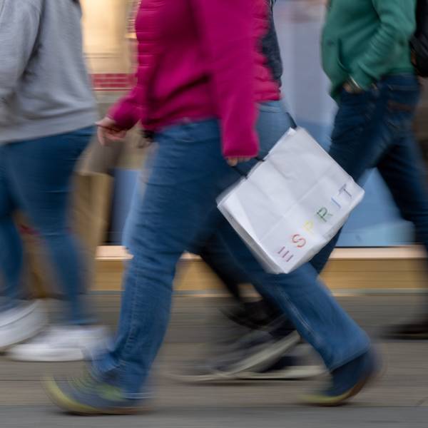 Menschen mit vollen Einkaufstaschen gehen an den Geschäften in der Tauentzienstraße vorbei.