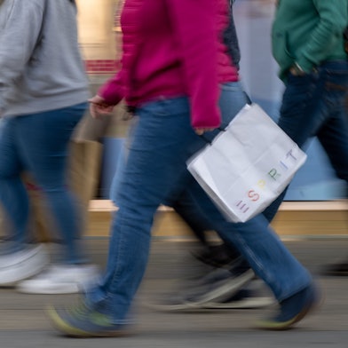 Menschen mit vollen Einkaufstaschen gehen an den Geschäften in der Tauentzienstraße vorbei.